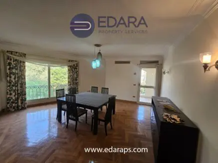Interior view of a dining area featuring a table with chairs and a sideboard in a well-lit room.