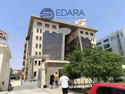 Modern multi-story building with a distinctive architectural design and glass facade in Cairo.