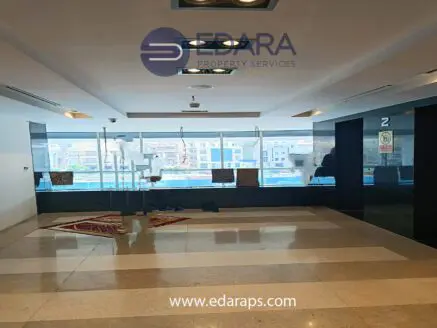 Interior view of a commercial space with large windows and a tiled floor, featuring the Edara Property Services logo.