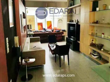 Interior view of a modern living room with a sofa, coffee table, and decorative shelves.