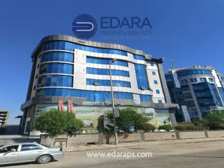 Modern multi-story building with glass windows and a prominent logo of Edara Property Services in Cairo.