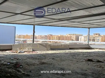 Interior view of an unfinished space with a metal roof and visible construction materials in Cairo.