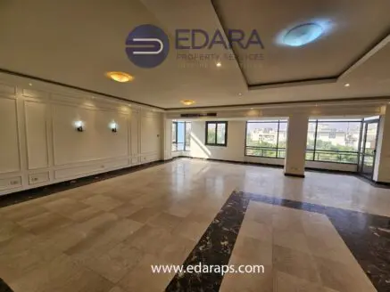 Spacious interior of a modern apartment with large windows and marble flooring in Cairo.
