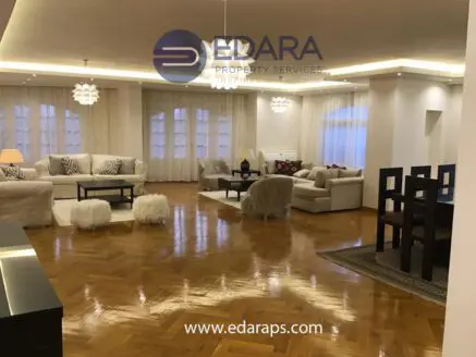 Spacious living room with modern furniture, wooden flooring, and soft lighting in a residential property.