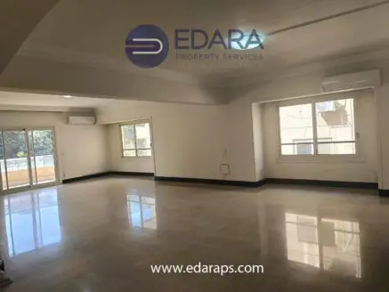 Spacious interior of an empty room with large windows and marble flooring in a property listing.