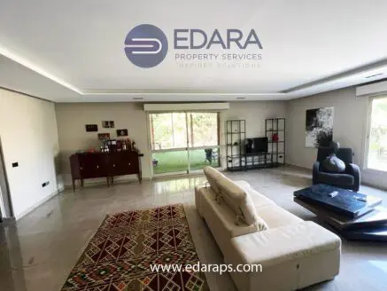 Spacious living room with modern furniture, large windows, and a decorative rug.