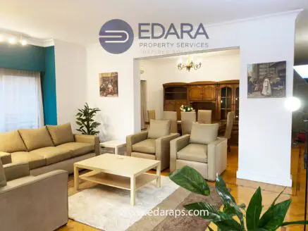 Living room with beige sofas, a coffee table, and decorative paintings on the walls.