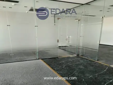 Interior view of a modern office space with glass partitions and a polished floor.
