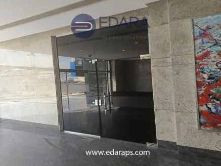 Modern glass entrance door with metal handles at a commercial building in Cairo.