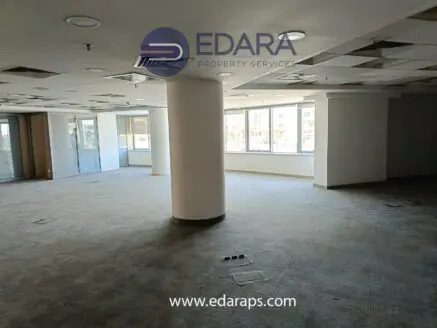 Interior view of an empty office space with carpet flooring and large windows at Edara Property Services.