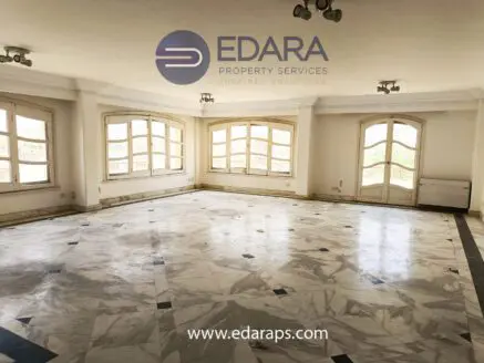 Spacious empty room featuring marble flooring and multiple large windows allowing natural light.
