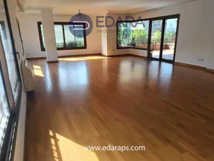 Empty room featuring wooden flooring and large windows allowing natural light.