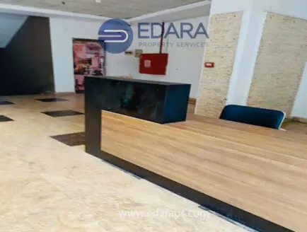 Reception desk with a wooden surface and black panel in an office space at Edara Property Services.