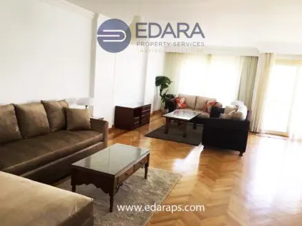 Spacious living room featuring beige sofas, a wooden coffee table, and a light-colored rug.