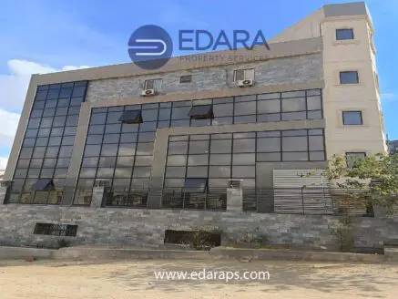 Modern commercial building with large glass windows and a stone facade in Cairo.