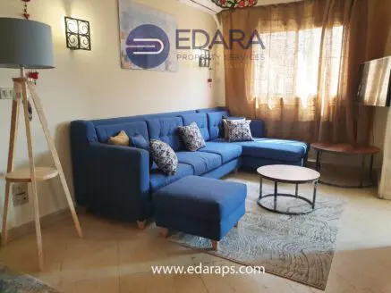 Living room featuring a blue sofa set with decorative pillows and a round coffee table.