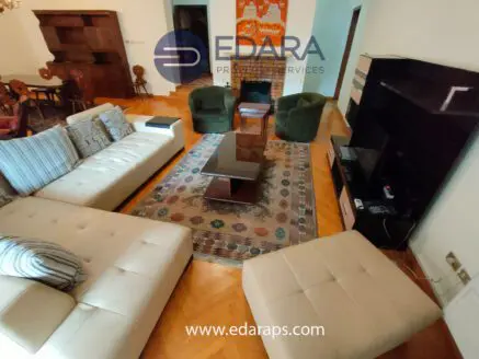 Spacious living room featuring a sectional sofa, coffee table, and two green armchairs.