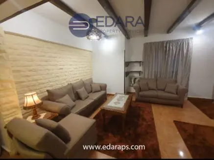 Living room featuring beige sofas, a decorative table, and a curtain in a neutral color scheme.