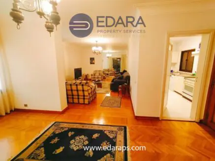 Interior view of a living room featuring a sofa set, television, and decorative carpet.
