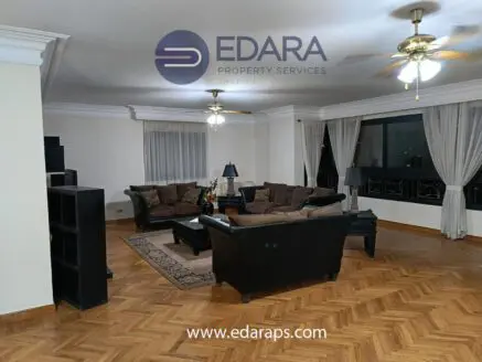 Living room featuring a dark sofa set, coffee table, and decorative elements in a spacious layout.