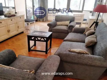Gray sofa set with decorative cushions and a wooden coffee table in a living room setting.