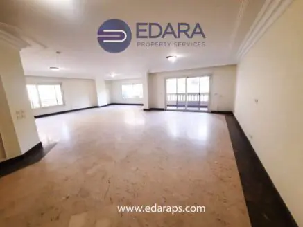 Interior view of a spacious room with marble flooring and ample natural light.
