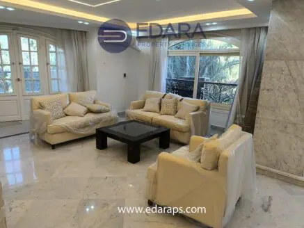 Living room featuring a beige sofa set with decorative cushions and a black coffee table on marble flooring.