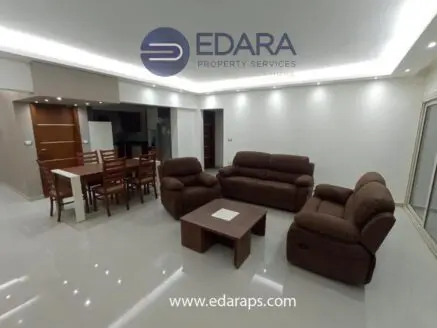 Interior view of a modern living room featuring brown sofas and a dining table.