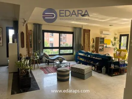Spacious living room with contemporary furniture, decorative items, and natural light from large windows.