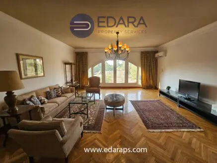 Living room featuring a sofa, armchair, coffee table, and a large window with natural light.