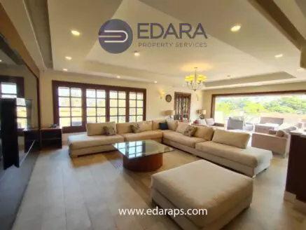 Spacious modern living room featuring a large sectional sofa and a wooden coffee table.