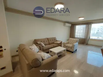 Living room featuring a beige sofa set with decorative cushions and a white coffee table.