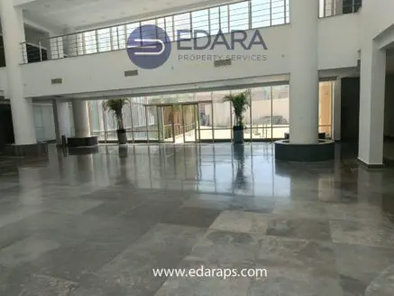 Spacious interior lobby featuring polished marble flooring and large windows allowing natural light.
