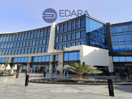 Contemporary commercial building featuring a glass facade and multiple storefronts in Cairo.