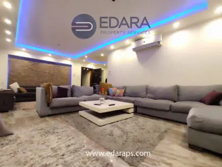 Contemporary living room featuring gray sofas, a coffee table, and decorative cushions.