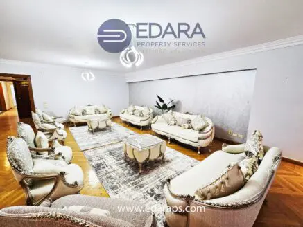 Luxurious living room furniture set with ornate details and a central coffee table on a patterned rug.