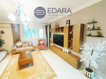 Modern living room featuring a sofa, coffee table, and wall-mounted television with decorative elements.