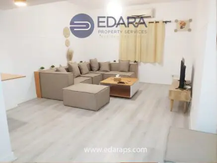 Contemporary living room featuring a modular sofa, coffee table, and television setup in a neutral color scheme.