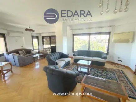 Spacious living room featuring a sofa set, coffee table, and decorative carpet.
