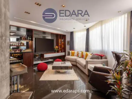 Contemporary living room featuring a large TV, comfortable seating, and decorative elements.