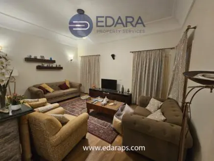 Cozy living room featuring two sofas, a coffee table, and a television on a stand.