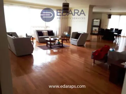 Spacious modern living room with wooden flooring and contemporary furniture arrangement.