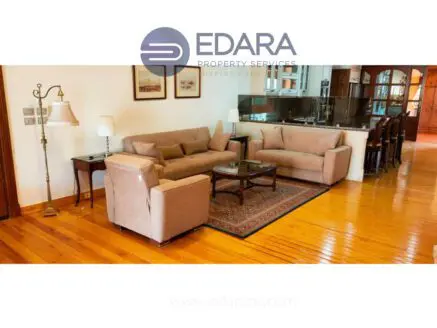 Living room featuring a beige sofa set, a coffee table, and wooden flooring.