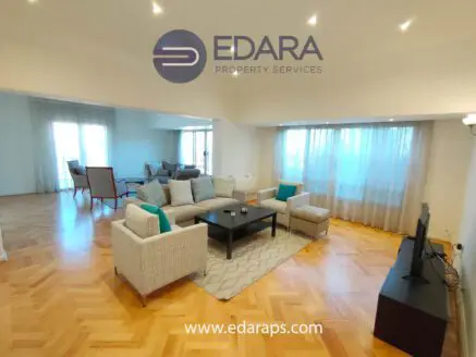 Bright living room featuring a comfortable seating arrangement and large windows for natural light.