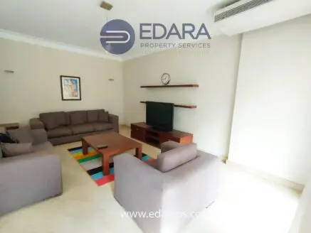 Living room featuring a sofa set, coffee table, and television on a wall-mounted shelf.