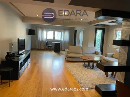 Spacious living room featuring a sofa, coffee table, and television on a media console.