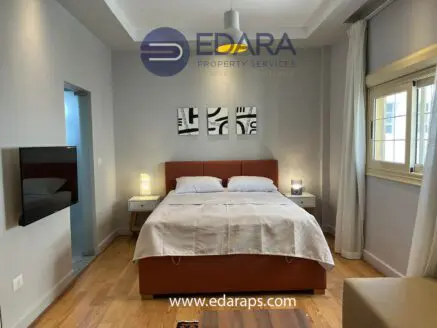 Contemporary bedroom featuring a bed with white linens and nightstands on either side.