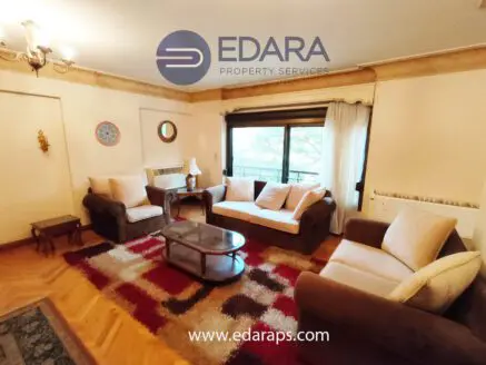 Cozy living room featuring a sofa set, coffee table, and decorative rug in neutral tones.