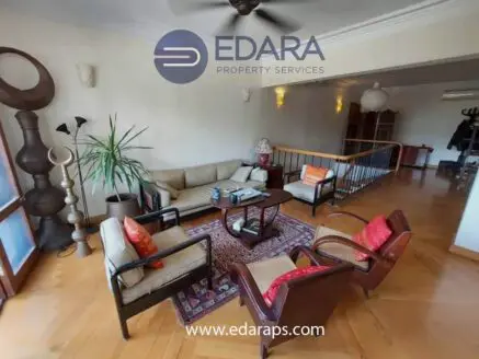 Seating arrangement in a living room with a sofa, chairs, and a coffee table on a wooden floor.