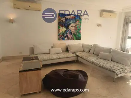 Contemporary living room featuring a sectional sofa and a colorful artwork on the wall.